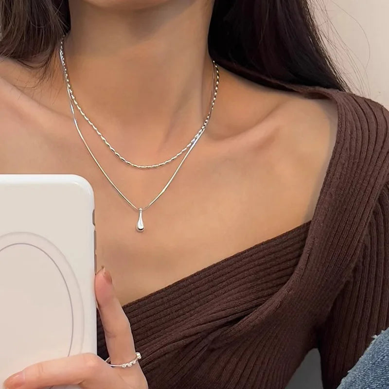 Halsband med dubbla kedjor och en droppformad berlock