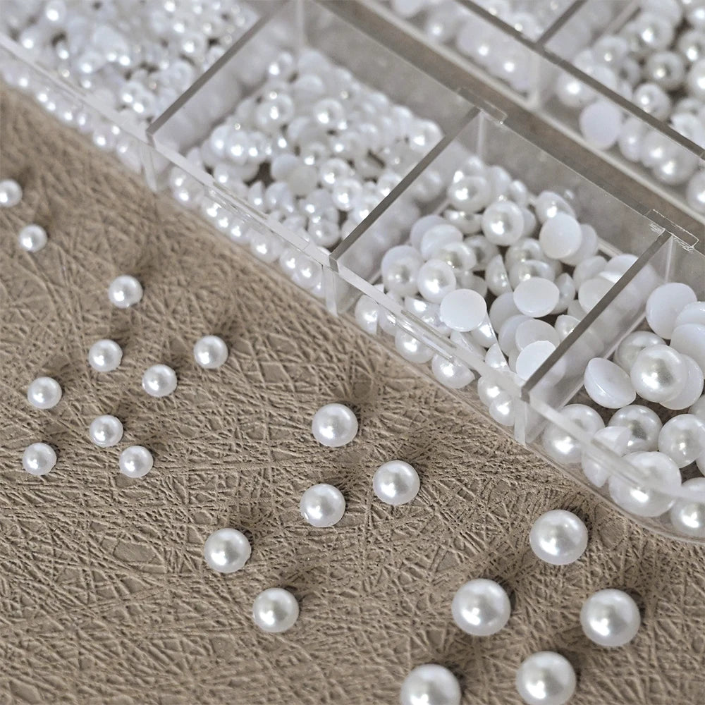 Låda med små pearls eller strass stenar med verktyg
