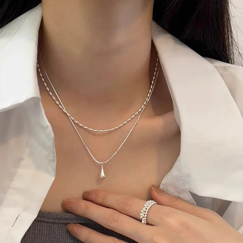Halsband med dubbla kedjor och en droppformad berlock