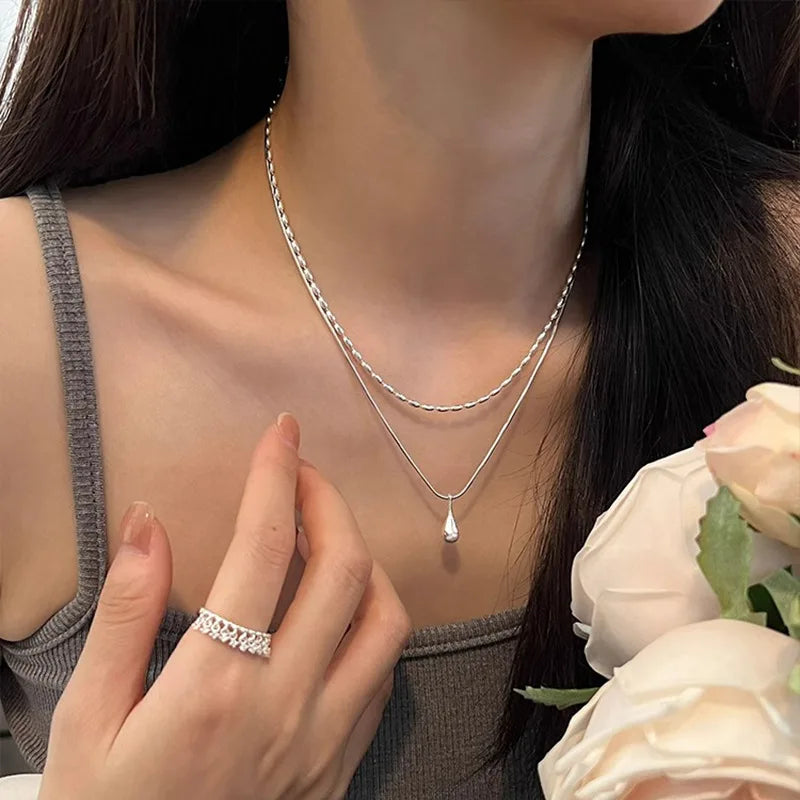 Halsband med dubbla kedjor och en droppformad berlock