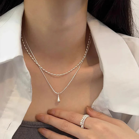 Halsband med dubbla kedjor och en droppformad berlock